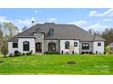 Beautiful home exterior with stone accents, manicured lawn, and professional landscaping at 129 Hunts Landing Dr, Mooresville, NC 28117