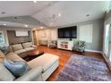 Open-concept living area with vaulted ceiling, hardwood floors, large TV, lots of natural light, and ceiling fan at 148 Palaside Ne Dr, Concord, NC 28025