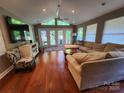 Spacious living room with hardwood floors, ceiling fan, large windows, and access to the outdoor deck at 148 Palaside Ne Dr, Concord, NC 28025