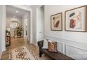 Stylish hallway featuring hardwood floors, decorative wainscoting, and a cozy bench with throw pillows at 16004 Tulloch Rd, Charlotte, NC 28278