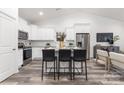 Well-lit kitchen featuring stainless steel appliances, an island, and stylish bar stools at 203 Park Ave, Mount Holly, NC 28120