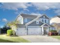 Attractive two-story home featuring three-car garage, manicured lawn, and beautiful blue siding at 2030 Bosna Ln, Fort Mill, SC 29715