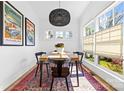 Sunlit dining room with modern chandelier, vintage posters, and light-filled windows at 210 Walford Dr, Charlotte, NC 28208