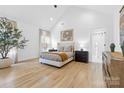Bright primary bedroom with vaulted ceiling, neutral tones, hardwood floors, and a luxurious en suite bathroom at 210 Walford Dr, Charlotte, NC 28208