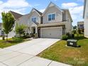 Two-story home featuring stone accents, a two-car garage, and a long concrete driveway at 3042 Burnello Ct, Iron Station, NC 28080