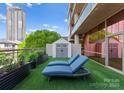 Relaxing rooftop patio featuring lounge chairs, lush greenery, and a stylish storage shed for comfortable outdoor living at 315 Arlington Ave # 506 & 507, Charlotte, NC 28203