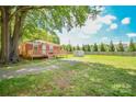 Picture of an expansive backyard with large tree, shed, and a wooden deck at 3203 Valleydale Rd, Monroe, NC 28110