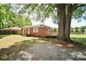 Expansive backyard with mature tree, deck, and gravel area at 3203 Valleydale Rd, Monroe, NC 28110