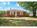 Charming brick home features a well-maintained lawn, fenced yard, and a small wooden deck perfect for enjoying the outdoors at 3203 Valleydale Rd, Monroe, NC 28110