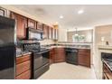 Functional kitchen with black appliances, tile backsplash, and cherry wood cabinets at 3420 Caldwell Ridge Pkwy, Charlotte, NC 28213