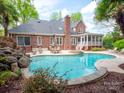 Backyard featuring a large swimming pool, hot tub, patio with furniture, and lush landscaping at 4721 Myers Ln, Harrisburg, NC 28075