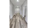 Inviting hallway featuring elegant archway, white trim and moldings, and modern wood-look flooring at 510 S Yadkin Ave, Spencer, NC 28159
