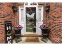 Welcoming front entrance with a decorated door, decorative planters, and a brick facade at 5629 Berry Ridge Dr, Harrisburg, NC 28075