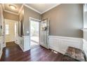 Inviting foyer featuring hardwood floors, elegant wainscoting, and a charming entry door with a decorative wreath at 6024 Glenmore Garden Dr, Charlotte, NC 28270