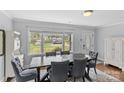 Bright dining room with large window and stylish decor, featuring a dark wood table and comfortable upholstered chairs at 6127 Rosecrest Dr, Charlotte, NC 28210