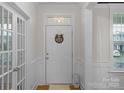 Entryway featuring neutral walls, a white front door with glass accents and wainscoting with hardwood flooring at 8008 Hudson Mill Dr, Waxhaw, NC 28173