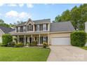 Charming two-story home with a welcoming front porch and lush landscaping at 879 Knightsbridge Rd, Fort Mill, SC 29708
