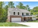 Beautiful exterior view of a home featuring a brick facade, gray siding and attached garage at 8937 Penstemons Dr, Charlotte, NC 28215