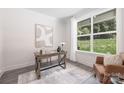 Bright office space featuring a wooden desk, chair, and a large window overlooking a lush yard at 8937 Penstemons Dr, Charlotte, NC 28215