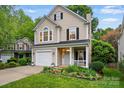 Charming two-story home with inviting front porch and well-maintained lawn with landscaped flower bed at 9209 Rotherham Ln, Charlotte, NC 28216