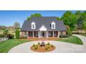 Inviting brick home with manicured lawn, mature trees, and circular driveway provides classic curb appeal at 105 Snead Ct, Salisbury, NC 28144