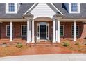 Elegant home entrance showcasing brick facade, white columns, and a stylish black front door at 105 Snead Ct, Salisbury, NC 28144