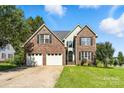 Inviting two-story brick home with a two-car garage, manicured lawn, and classic black shutters at 1050 Merrywood Dr, Newton, NC 28658