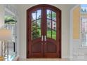 Elegant arched double front doors with glass panels, providing a glimpse of the beautiful outdoors at 11424 Stonebriar Dr, Charlotte, NC 28277