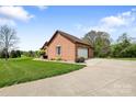 Brick home featuring an attached garage with a white door, a driveway, and landscaped front yard at 121 Capstone Ct, Statesville, NC 28625