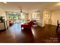 Bright living room with hardwood floors, balcony access, open to kitchen, and stylish furnishings at 1300 Queens Rd # 210, Charlotte, NC 28207