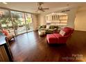 Inviting living room featuring dark hardwood floors, balcony access, an open kitchen view, and modern decor at 1300 Queens Rd # 210, Charlotte, NC 28207