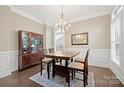 Traditional dining room with hardwood floors, wainscoting, and a classic chandelier at 13044 Fen Ct, Huntersville, NC 28078