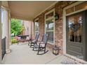 Inviting front porch featuring rocking chairs, bench, and views of the landscaped yard at 13044 Fen Ct, Huntersville, NC 28078