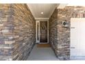 Inviting front entrance featuring a stone facade, covered porch, and a decorative wreath on the brown front door at 15710 Oleander Dr, Charlotte, NC 28278