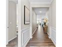 Elegant hallway with hardwood floors, wainscoting, neutral paint, and open view into the living area at 15710 Oleander Dr, Charlotte, NC 28278