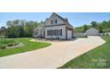 Expansive view of the house with a long driveway that leads to the garage and a well-maintained lawn at 16610 Blackberry Hills Dr, Midland, NC 28107