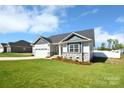 Inviting home showcasing a well-maintained lawn, two-car garage, and attractive stone detailing at 221 Mountain Island Dr, Statesville, NC 28677