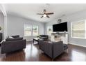 Spacious living room with hardwood floors, a ceiling fan, and plenty of natural light from the windows at 2220 Atwell Glen Ln, Pineville, NC 28134