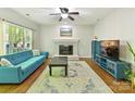 Bright living room features a cozy fireplace, large window, hardwood floors and a comfortable blue sofa at 2805 Bathgate Ln, Matthews, NC 28105