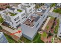 Aerial shot of modern townhome exteriors with rooftop patio and attached garages and lush landscaped yards at 310 Wesley Heights Way, Charlotte, NC 28208