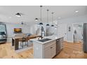 Modern kitchen open to living area featuring stainless appliances, island with sink, and hardwood floors at 310 Wesley Heights Way, Charlotte, NC 28208