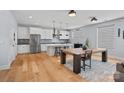 Bright, open kitchen featuring modern appliances, a large island, and a seamless flow into the dining area at 310 Wesley Heights Way, Charlotte, NC 28208