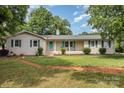 Charming one story brick home with a well-maintained lawn and inviting front porch at 334 Hudson Dr, Harrisburg, NC 28075