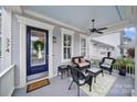 Inviting front porch with wicker seating, ceiling fan, welcome mat and blue painted front door with decorative wreath at 374 Horton Grove Rd, Fort Mill, SC 29715