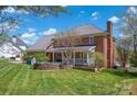 Lush backyard with a brick house, covered porch, and a charming stone-lined planter at 4405 3Rd Nw St, Hickory, NC 28601