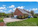 Long driveway leads to a brick house with a two-car garage surrounded by lush landscaping at 4405 3Rd Nw St, Hickory, NC 28601