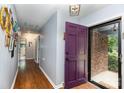 Inviting foyer with wood flooring, purple door, and access to various rooms at 4813 Carving Tree Dr, Mint Hill, NC 28227