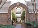Charming brick archway offering a serene view of a landscaped courtyard with a central fountain in the condo community at 5007 Sharon Rd # R, Charlotte, NC 28210