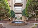 Courtyard with a circular fountain, flanked by well-maintained greenery and condo buildings, creating a peaceful atmosphere at 5007 Sharon Rd # R, Charlotte, NC 28210