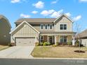 Beautiful two-story home with a covered porch, attached garage, and manicured front lawn under a bright sky at 5532 Muckross Ln, Fort Mill, SC 29707